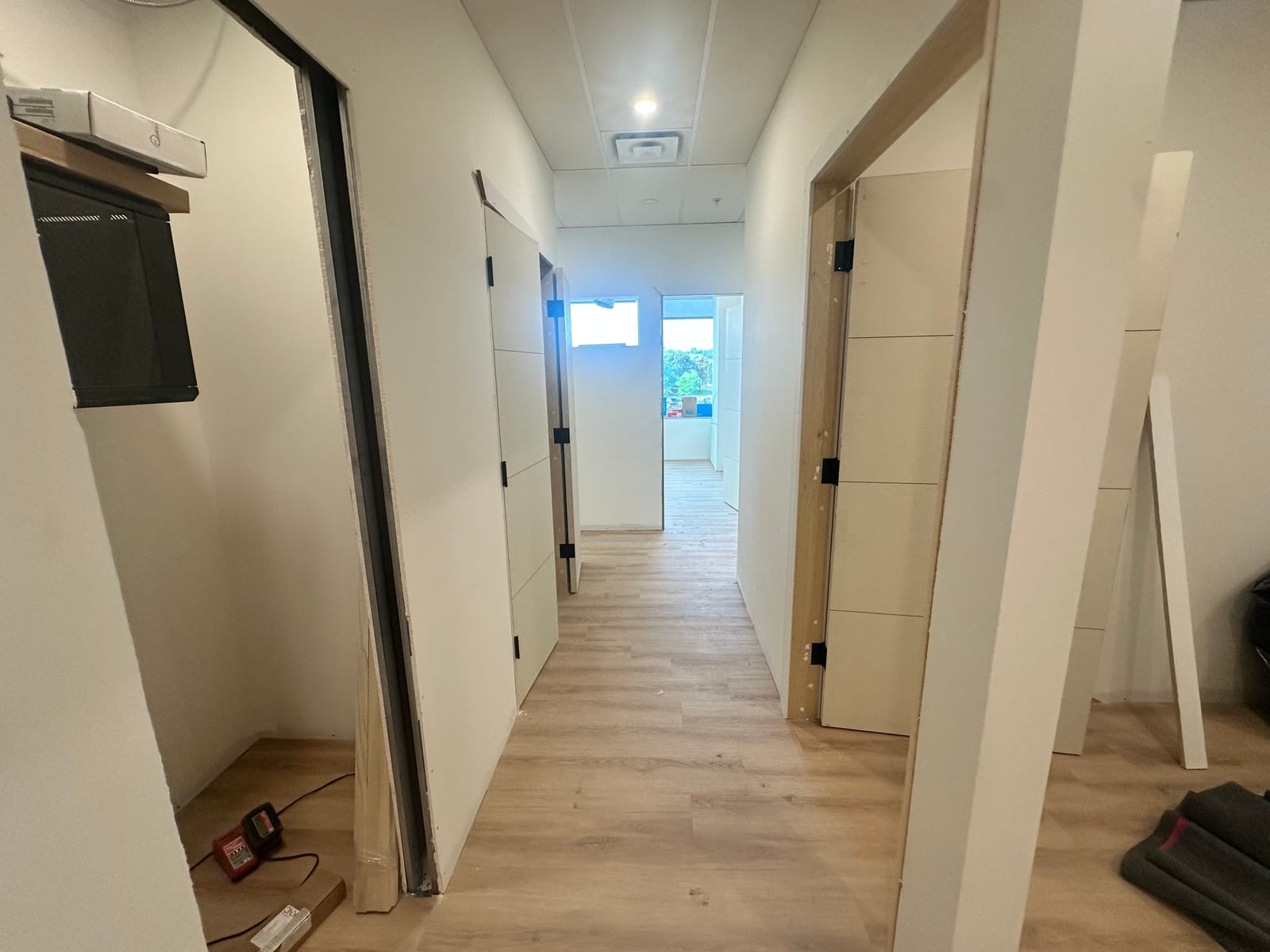 Finished hallway with drywall, doors, and T-bar ceiling