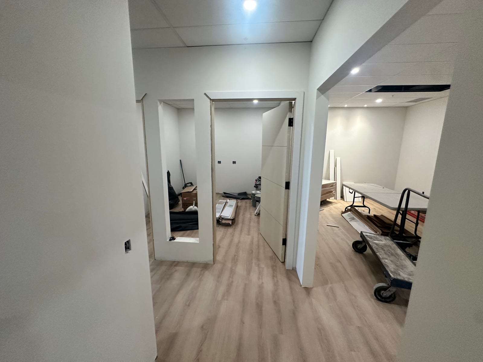 Finished hallway with T-bar ceiling, drywall, and door ready to hang